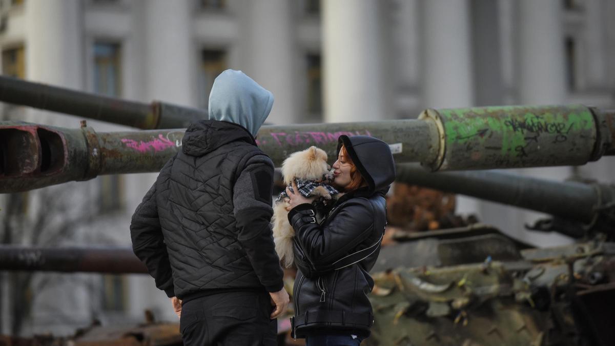 Una pareja junto a una instalación de vehículos militares rusos destruidos, en el centro de Kiev.