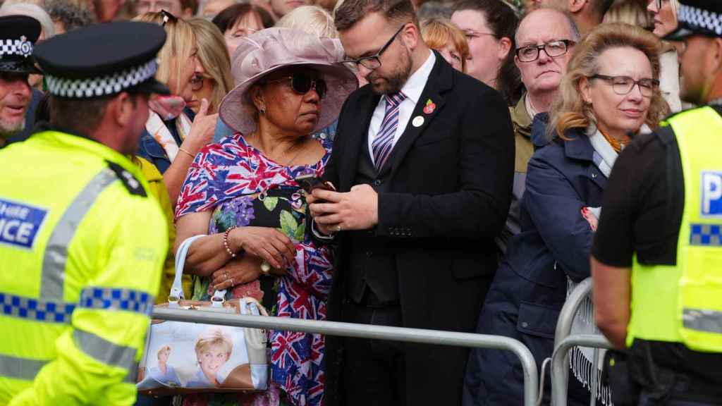 La femme qui s'est rendue à la cathédrale avec un sac avec l'image de Lady Di imprimée dessus.