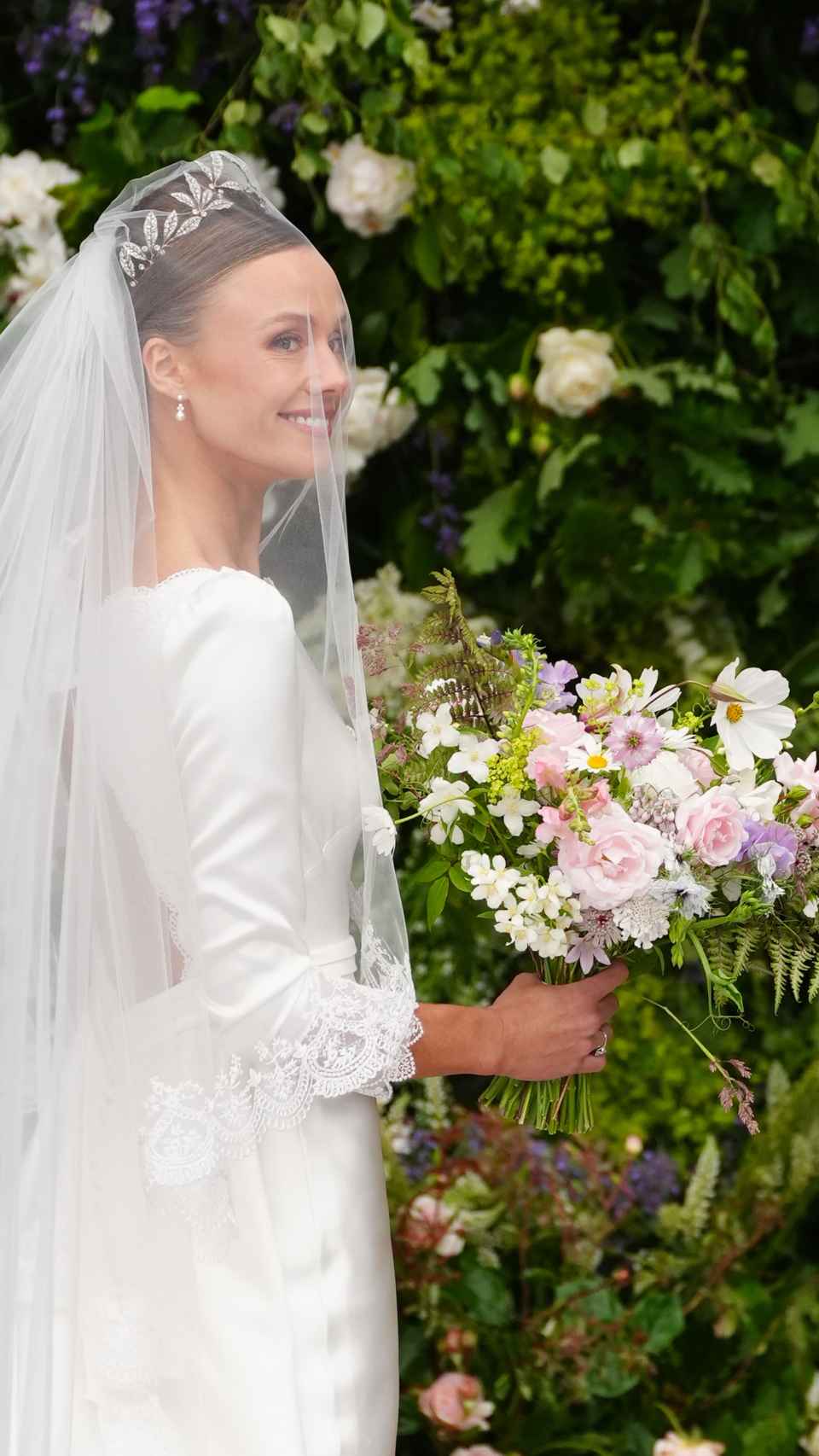 La mariée, souriante, arrive à l'église pour dire « oui ».