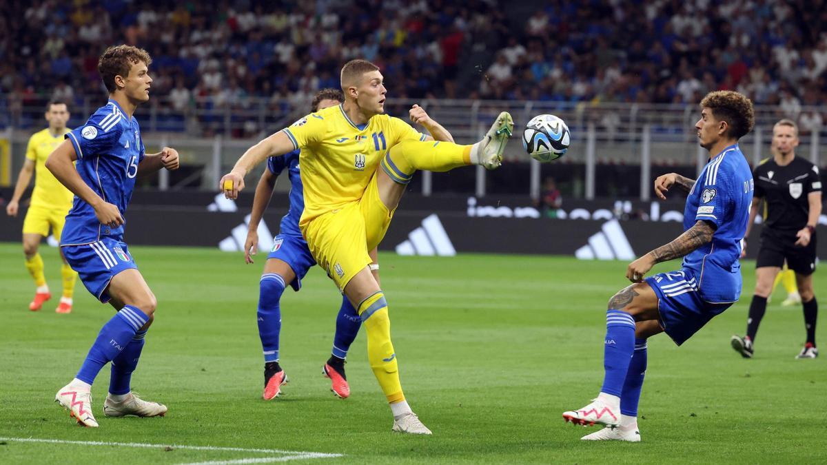 Dovbyk attaque un ballon entouré de défenseurs italiens lors de la phase de qualification.