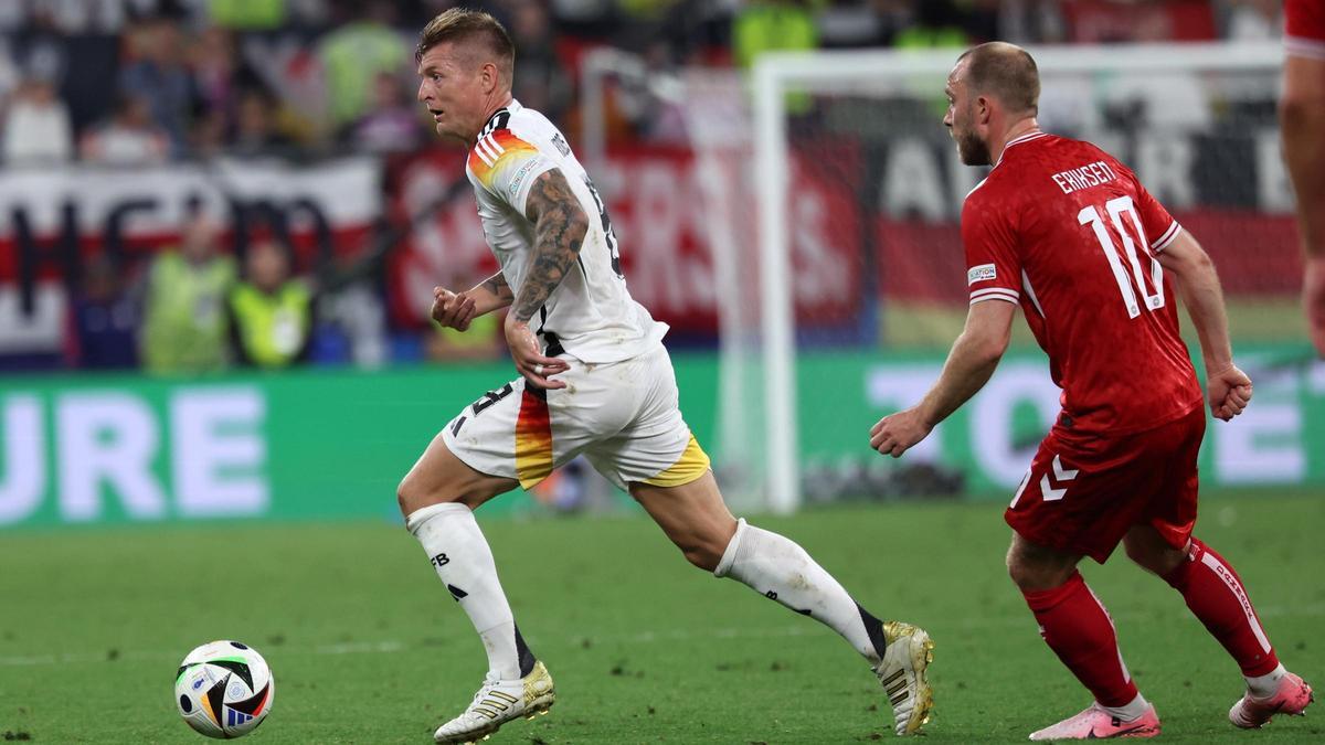 Kroos passe le ballon devant le Danois Eriksen.