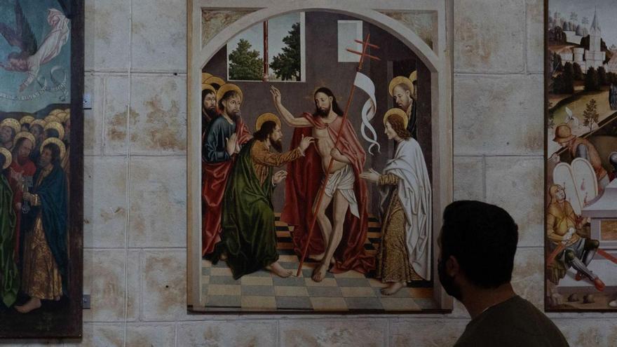 Un hombre admira las tablas de Fernando Gallego en la iglesia de Arcenillas.