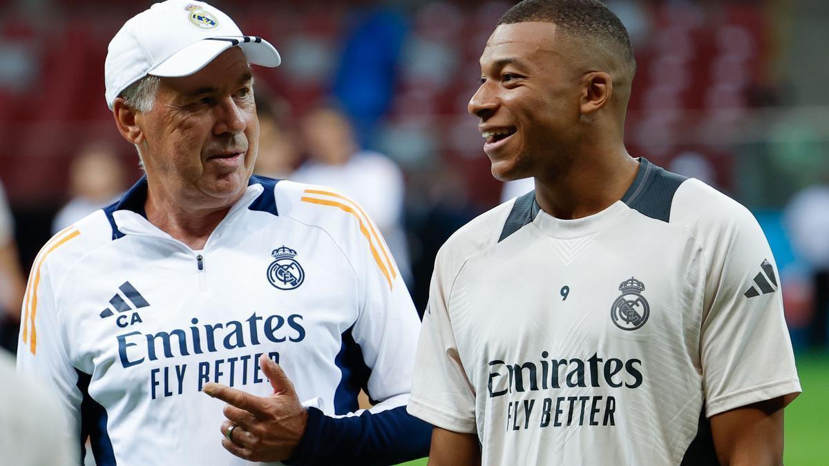 El nuevo delantero del Real Madrid, el francés Kylian Mbappé (d) recibe instrucciones de su entrenador, el italiano Carlo Ancelotti.