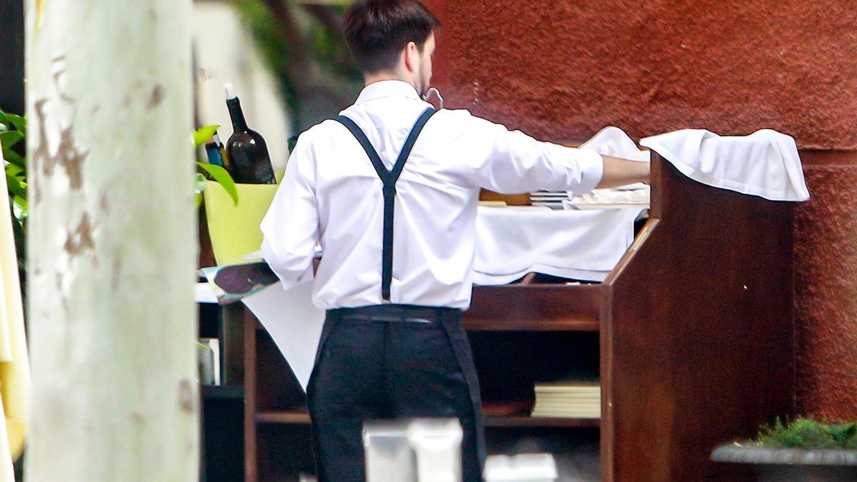 Un camarero atiende a los clientes de una terraza.