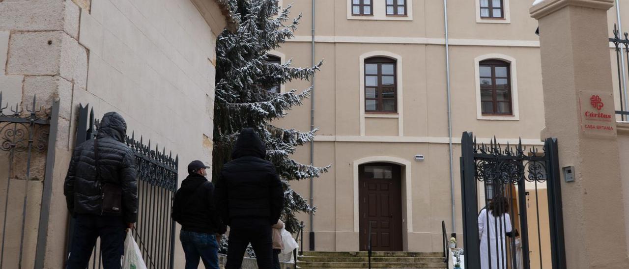 Varias personas esperan el reparto de comida en Casa Betania, perteneciente a Cáritas.