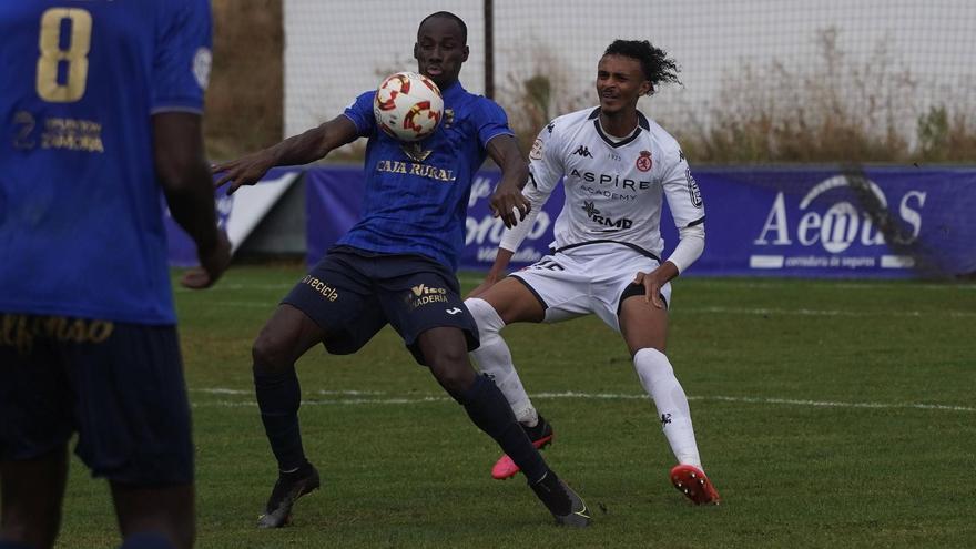 Una jugada de partido disputado bajo la lluvia