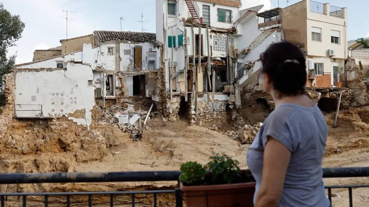Una mujer observa varias casas dañadas en Chiva (Valencia) tras la dana.