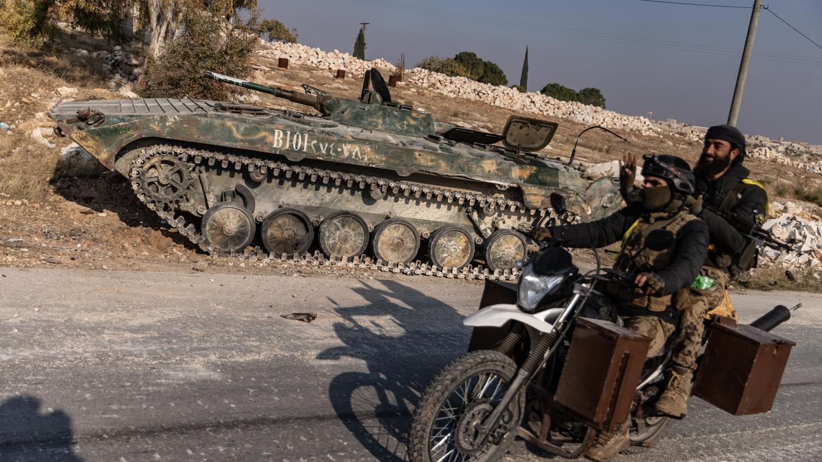 29 de noviembre de 2024,Kafr Naya, Siria. Opositores pasan junto a un tanque capturado del ejército sirio