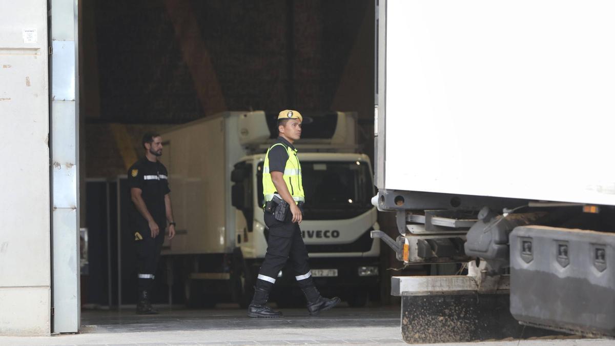 Soldados de la UME custodian los vehículos frigoríficos en los que permanecen los cuerpos antes de su entrega a las funerarias.