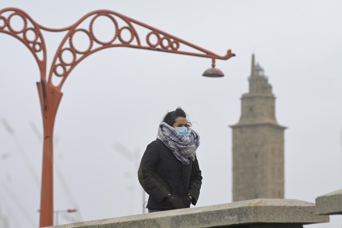 Dossier - Une personne marche à l'abri du froid sur le Paseo Marítimo de La Corogne.