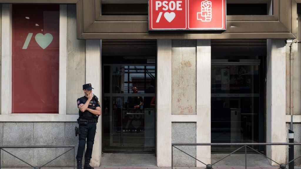Un agente de Policía aguarda en la entrada de la sede del Partido Socialista