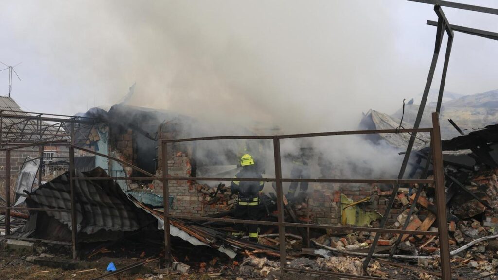 Bomberos ucranianos en el lugar del impacto de un proyectil ruso, este miércoles, en Járkov.