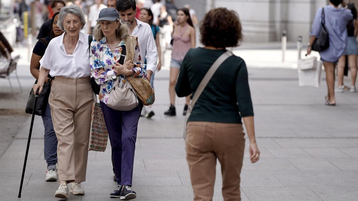 Personas mayores paseando por el centro de Madrid.