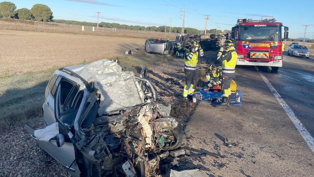 Los bombero en el lugar del accidente de tráfico entre un camión y dos turismos en la N-601, en La Pedraja de Portillo (Valladolid).