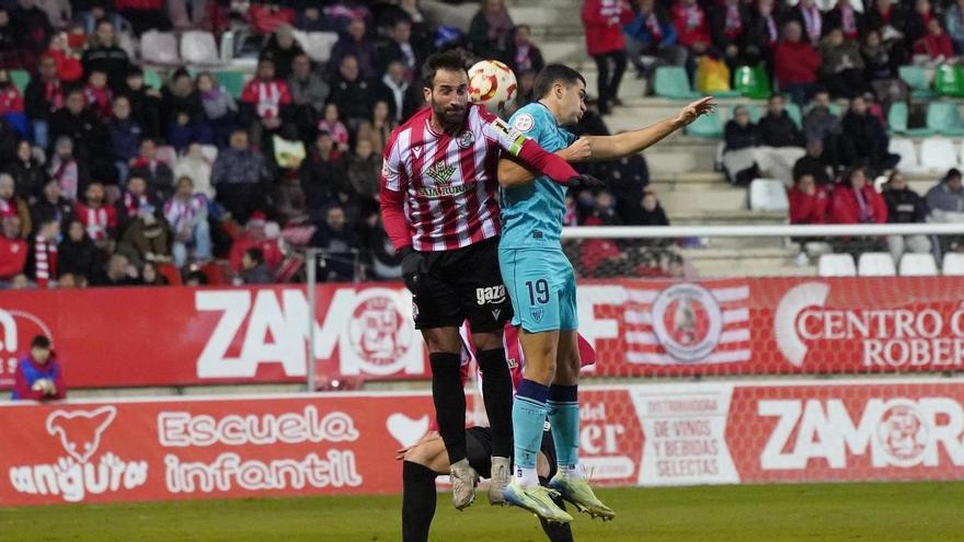 Dos jugadores pugan por un balón dividido.