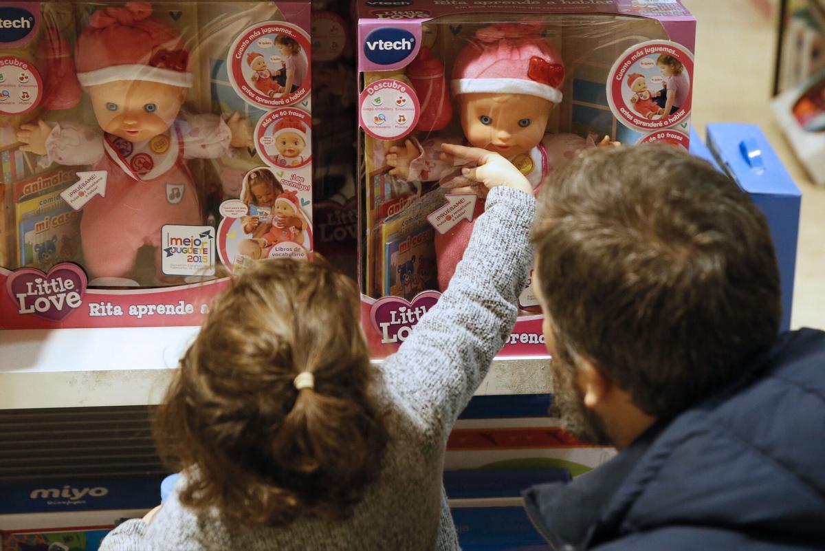 Une fille inspecte une poupée dans un magasin de jouets à Valence.gra065. Madrid, 03/01/2017.- Deux enfants regardent des poupées dans un centre commercial à Madrid. "Moins c'est plus" est la phrase utilisée par les experts consultés par EFE pour encourager les parents à éviter les dons excédentaires le jour des rois dans le but que les petits apprennent à les apprécier et peuvent en profiter pleinement. Dans cette campagne de Noël, l'association espagnole des fabricants de jouets attend