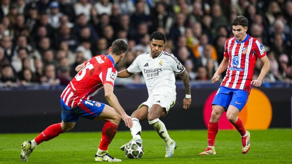 Rodrygo Goes, jugador del Real Madrid, disputa un balón ante Clement Lenglet y Julián Álvarez, del Atlético, en la ida de la Champions.