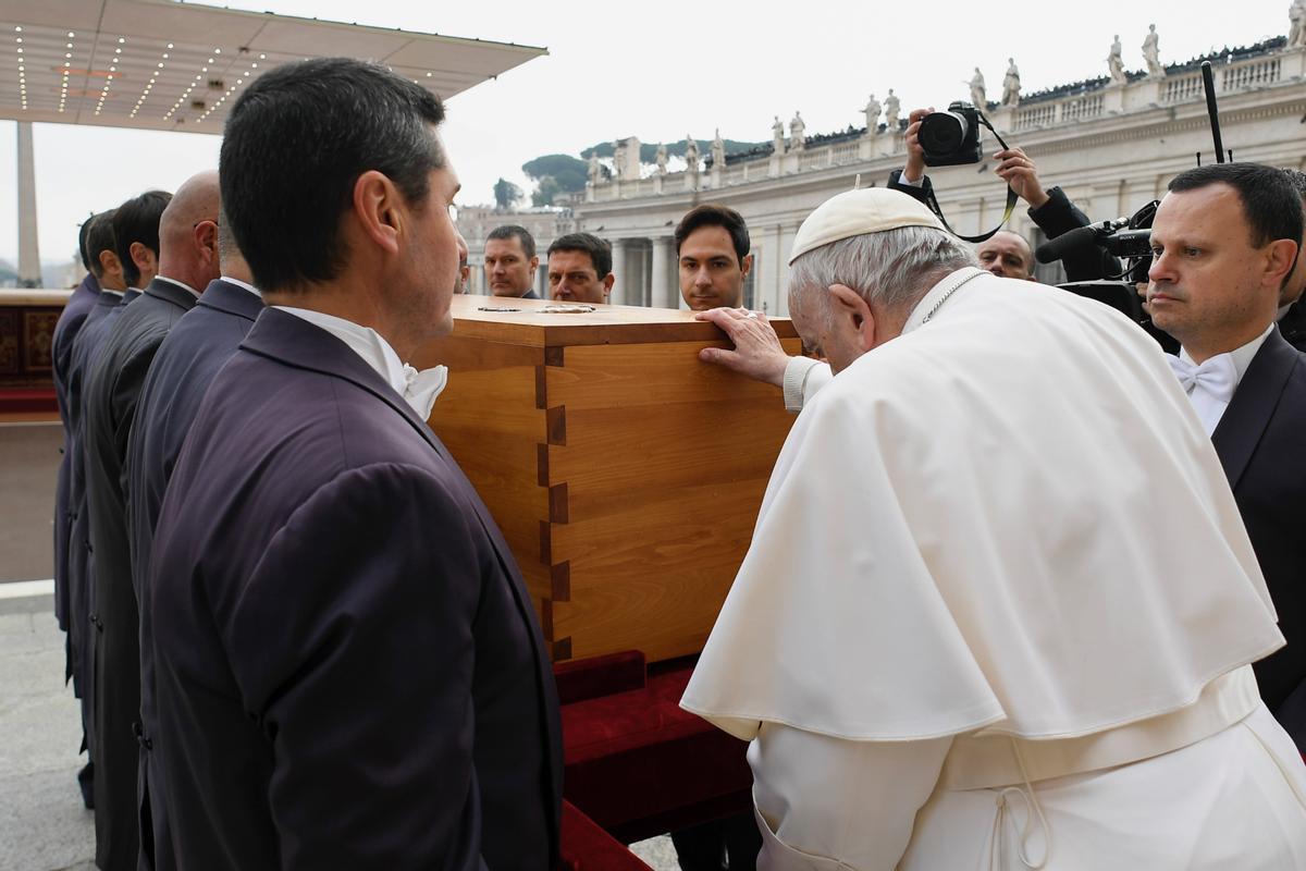 Francisco posant sa main sur le cercueil de son prédécesseur, Benoît XVI.