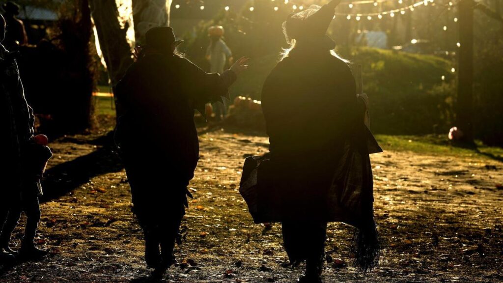 Dos mujeres disfrazadas de brujas, en un parque.