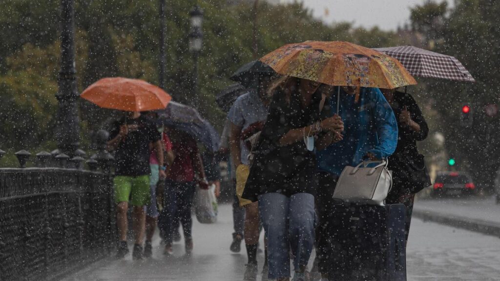 Varias personas caminan bajo sus paraguas el día en que han puesto en aviso amarillo a la Comunidad de Andalucía por tormentas y lluvias. Imagen de archivo.