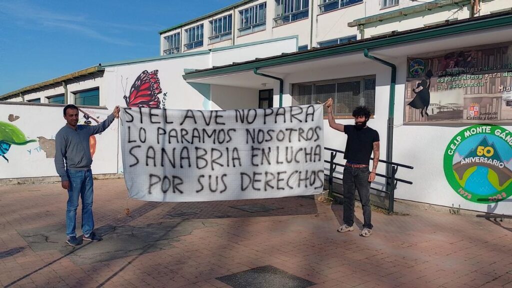 Dos vecinos de Sanabria muestran una pancarta de protesta contra la decisión de Renfe.