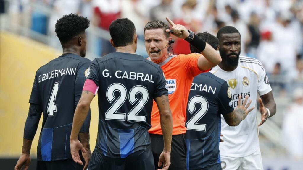 Eduardo Bauermann y Gustavo Cabral, capitán del Pachuca, alegan con el árbitro brasileño Ramon Abatti durante el partido ante el Real Madrid. EFE/EPA/ERIK S. LESSER