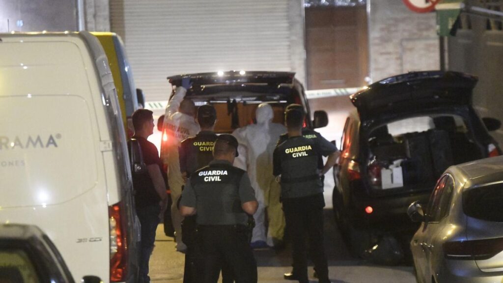 Los agentes trasladan el cadáver hallado en una vivienda de Cabezo de Torres.