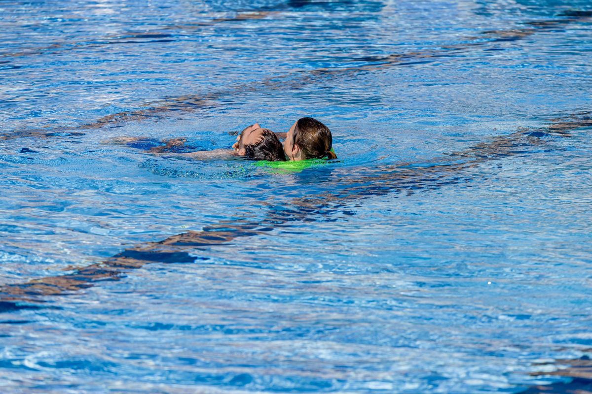 Les membres de Summa 112 effectuent une simulation de sauvetage et de réanimation cardiopulmonaire (RCR) en cas de noyade, dans les installations sportives du canal de Isabel II, le 25 juillet 2023, à Madrid (Espagne).