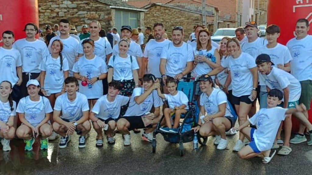 Participantes en la marcha posan con el pequeño Manuel, que también participó en la actividad con su silla.