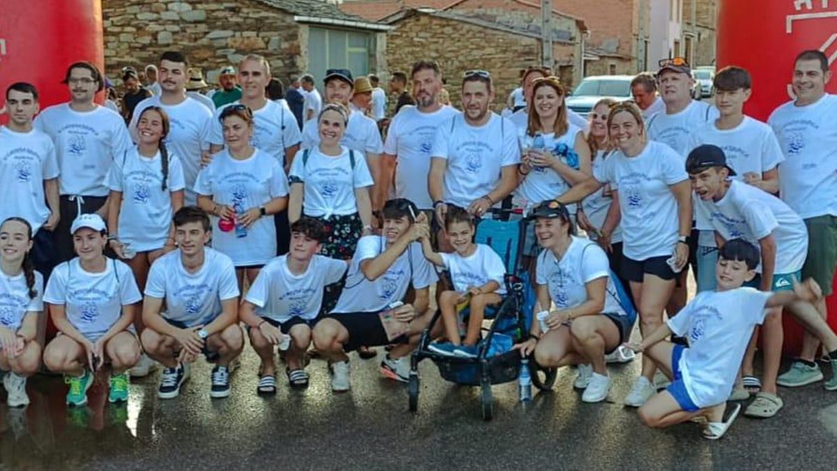 Participantes en la marcha posan con el pequeño Manuel, que también participó en la actividad con su silla.