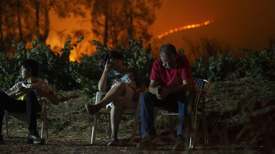 Una familia, desolada por el avance del incendio en Valdeorras, la noche del viernes al sábado.