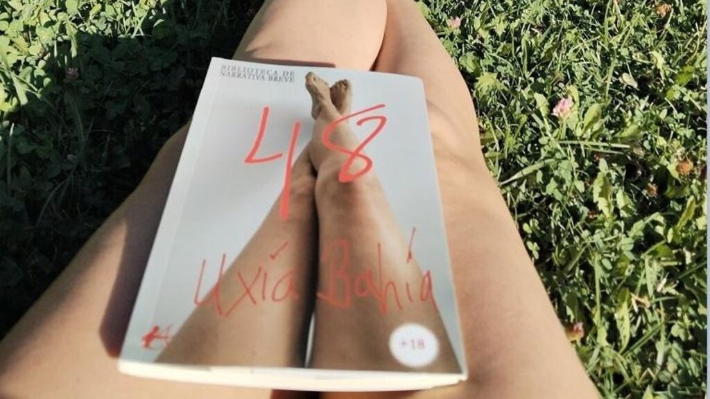 La pontevedresa Uxía Bahía posa con un ejemplar de su libro en un parque.