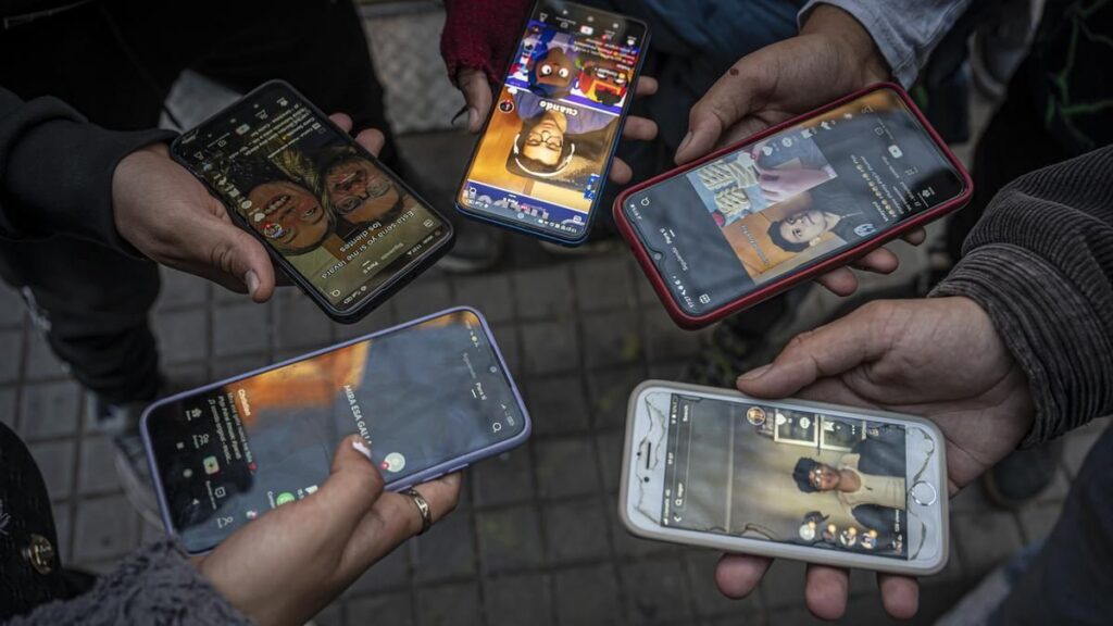 Un grupo de jóvenes, usando TikTok en la calle