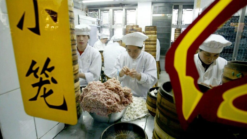 Trabajadores preparan bollos al vapor rellenos de carne de cerdo en una cafetería de Shanghái.