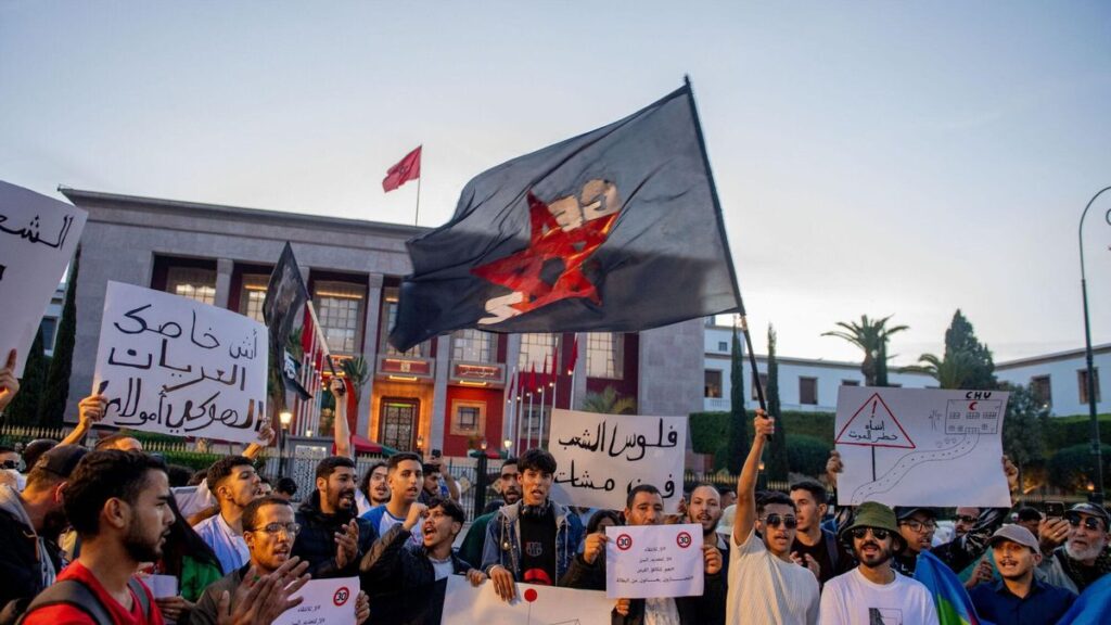 Manifestantes sostienen pancartas y ondean banderas durante una protesta organizada por el colectivo autodenominado 'GenZ 212' en Rabat.