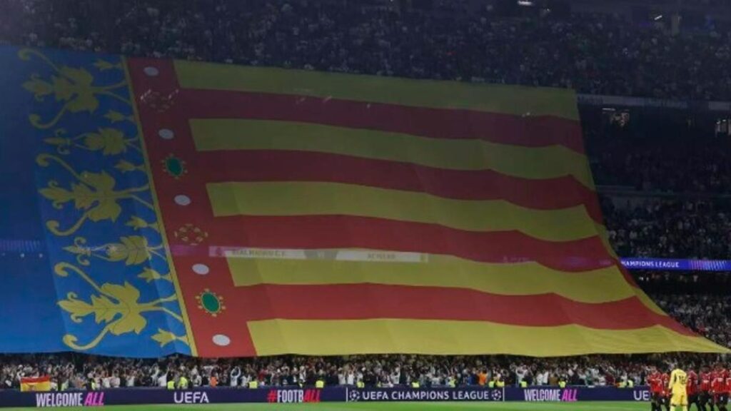 Los jugadores del Milan ante la bandera valenciana, antes del partido de la Liga de Campeones frente al Madrid, en el Santiago Bernabéu