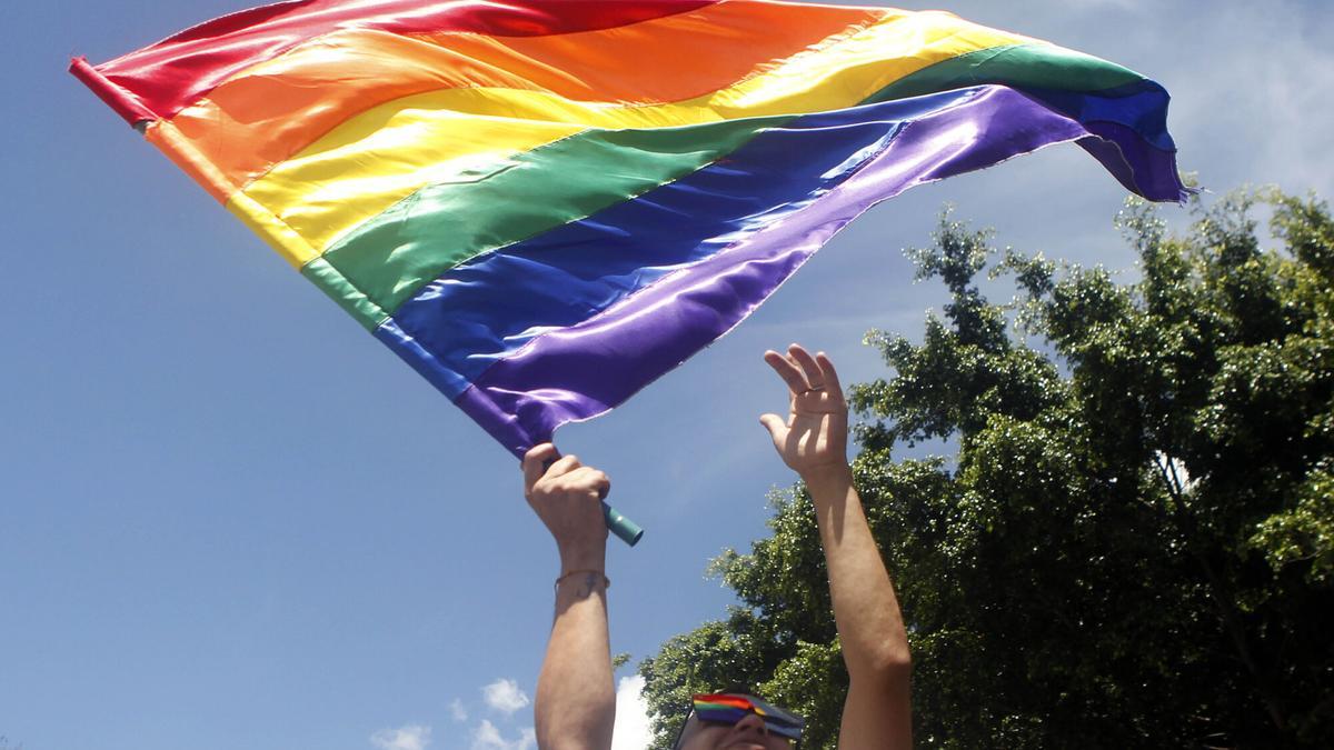Un hombre agita una bandera LGBTI durante la marcha del orgullo gay.