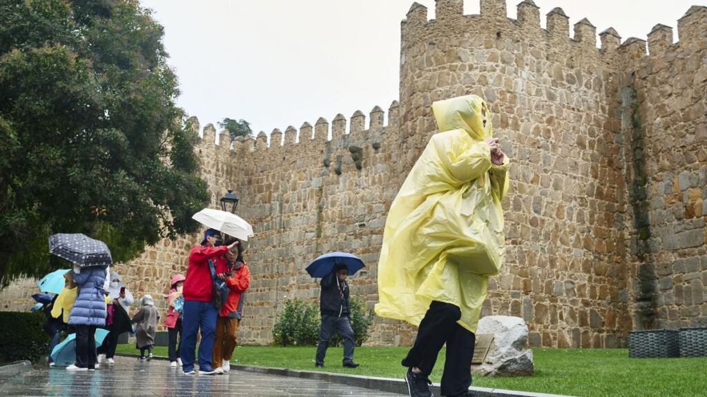 Varias personas se protegen de la lluvia este jueves en Ávila.