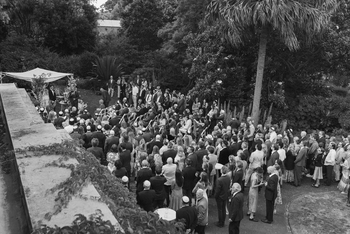 Moment de cérémonie juive Bedekken avec les mariés entourés de leur famille dans un jardin