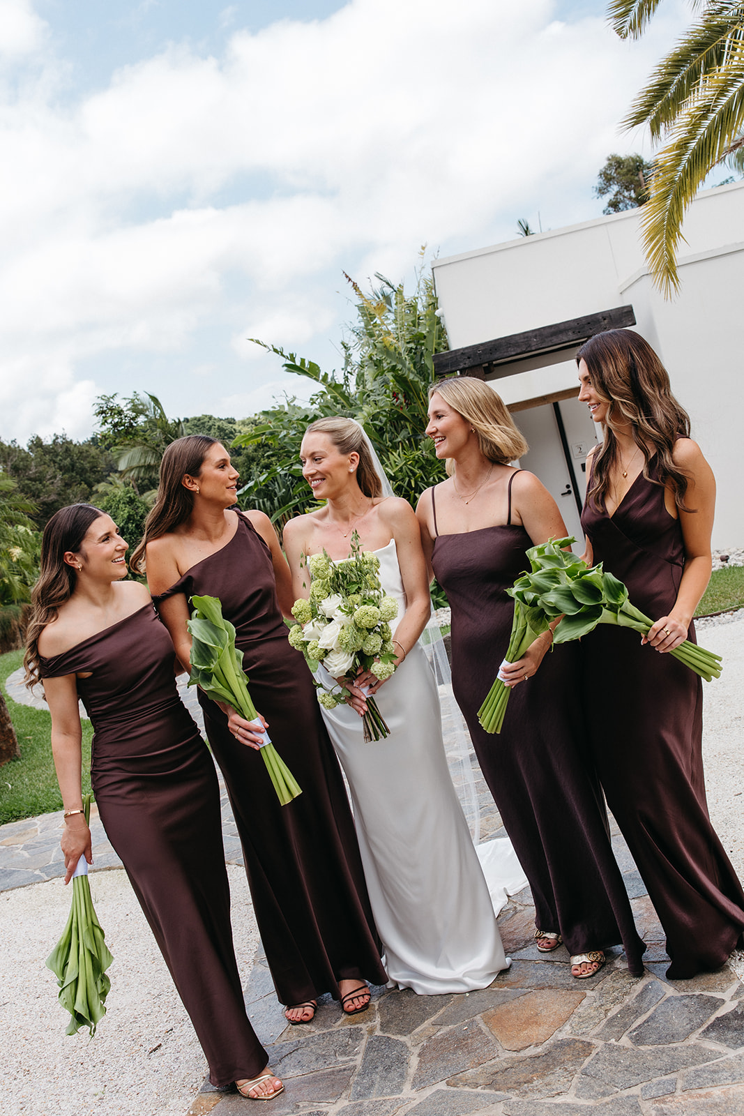 Demoiselles d'honneur portant des robes marron Bec et Bridge tenant des bouquets verts uniques