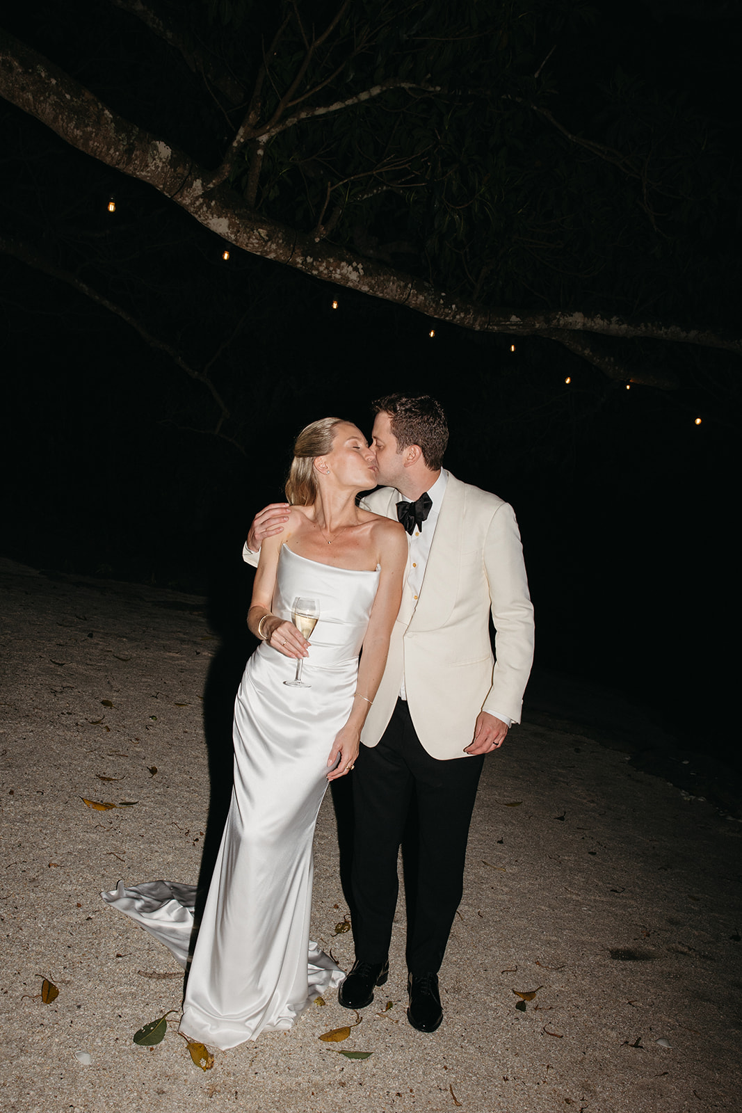 Les jeunes mariés se promènent dans l'arrière-pays de Byron Bay à la tombée de la nuit lors de leur réception de mariage