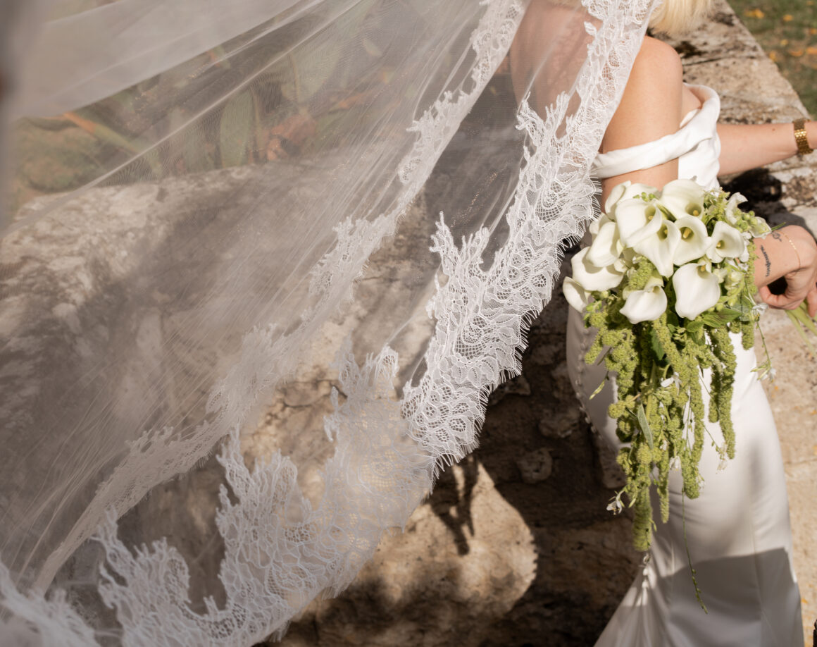 Mariée en robe de mariée moderne marchant dans les jardins du château français