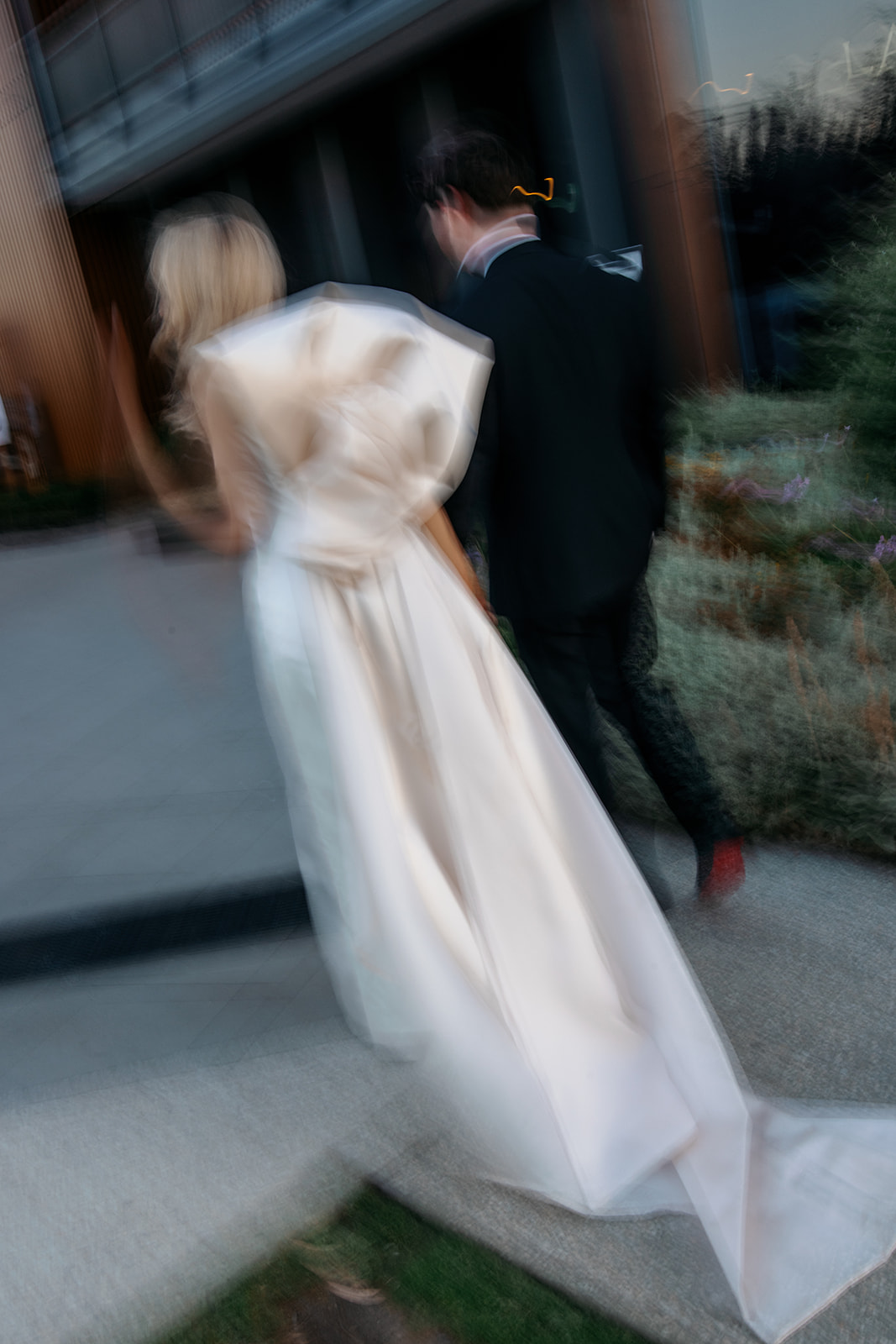 Flou de mouvement franc des mariés marchant ensemble à Marnong Estate Winery, Melbourne, robe de mariée en soie personnalisée de la mariée avec nœud au dos capturé dans une photographie de mouvement par Kinship by Kristy
